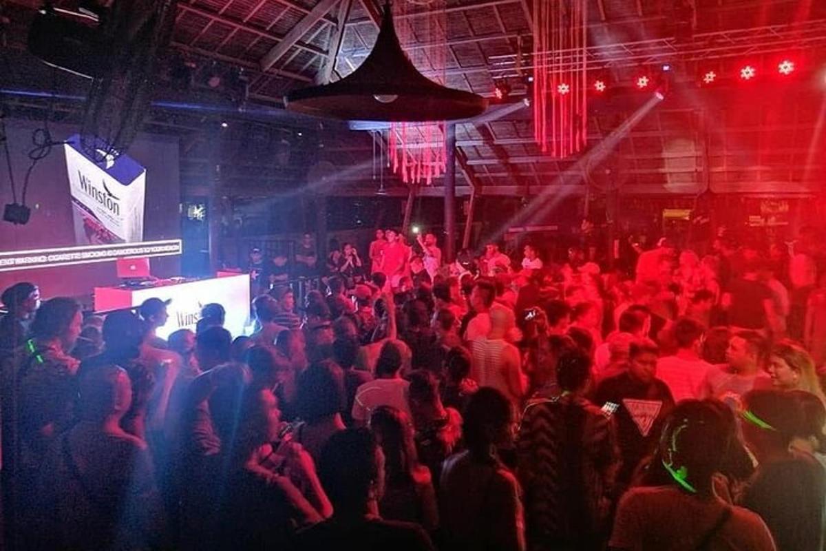 a crowd of people in a room with red lights