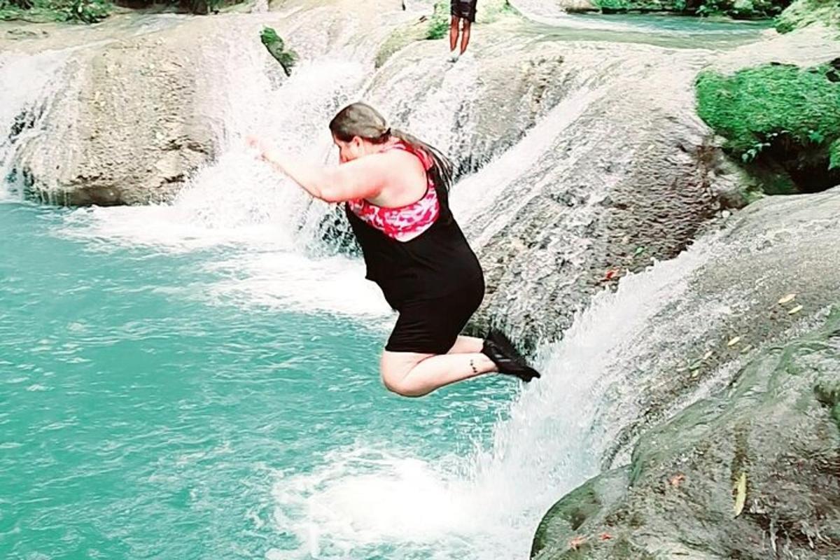 una dona saltant d'una cascada a un riu