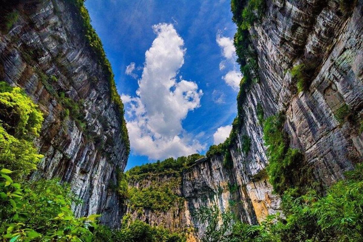 uma vista de um cânion com céu azul e nuvens