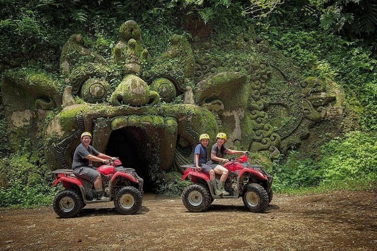 tre persone in sella a un quad davanti a un tunnel