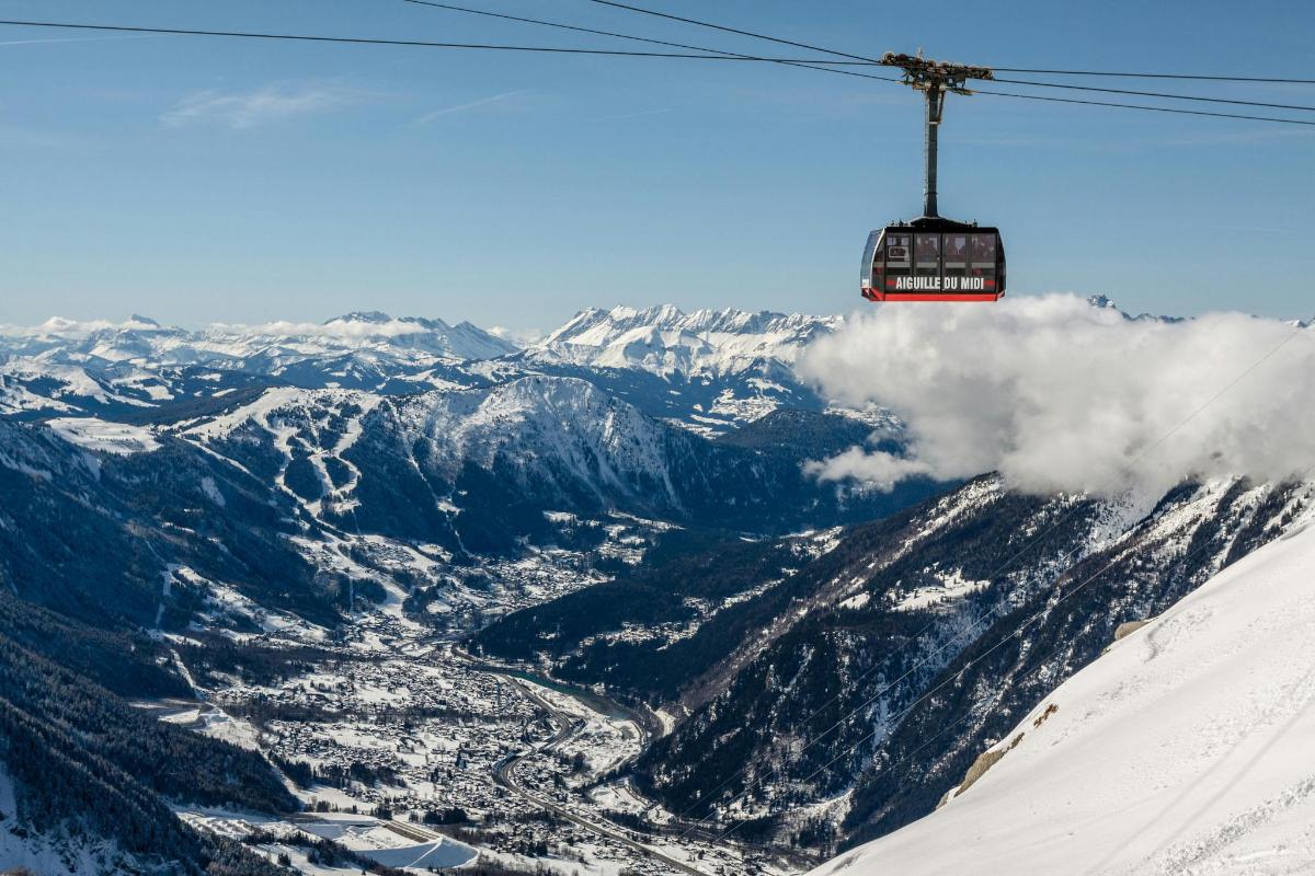 a ski lift flying over a snow covered mountain