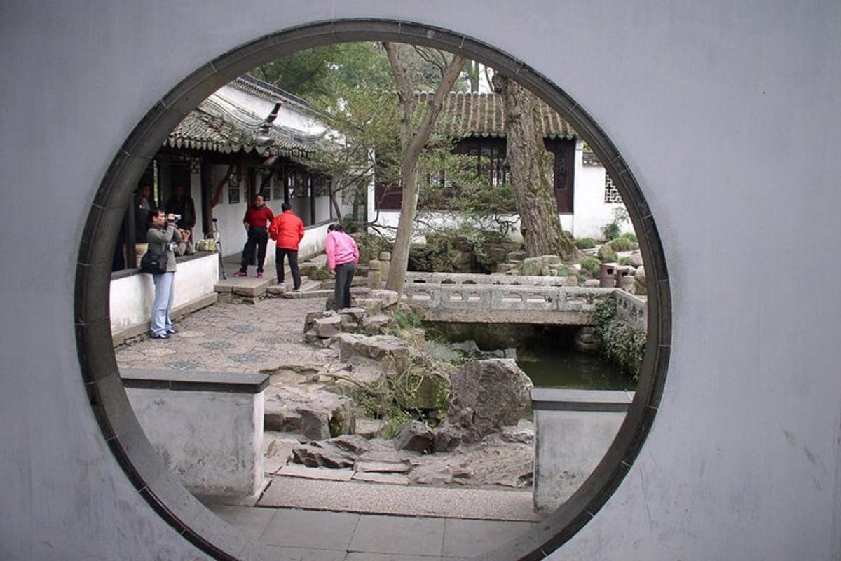 a round mirror reflecting a garden with people in it