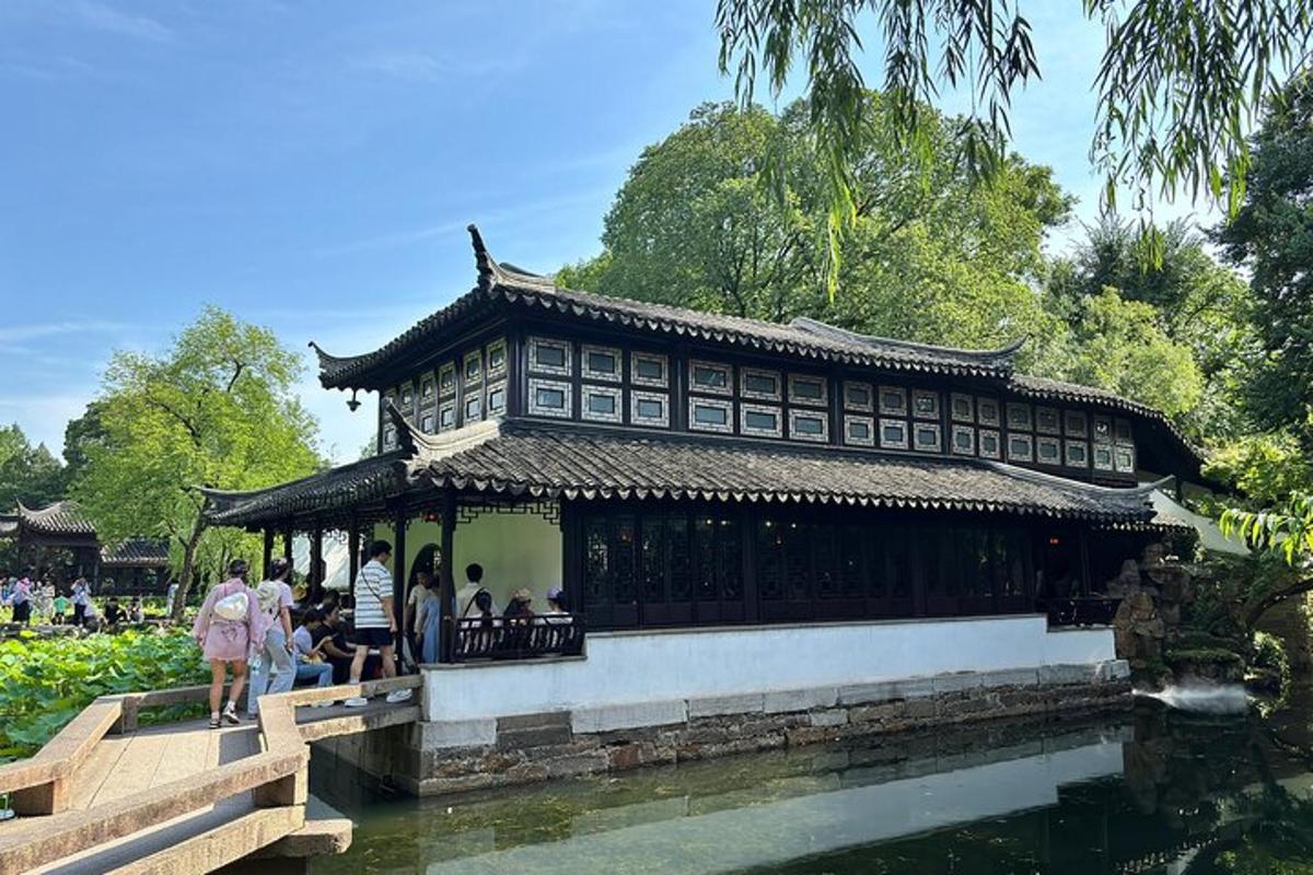 a building with people standing on a bridge over a body of water