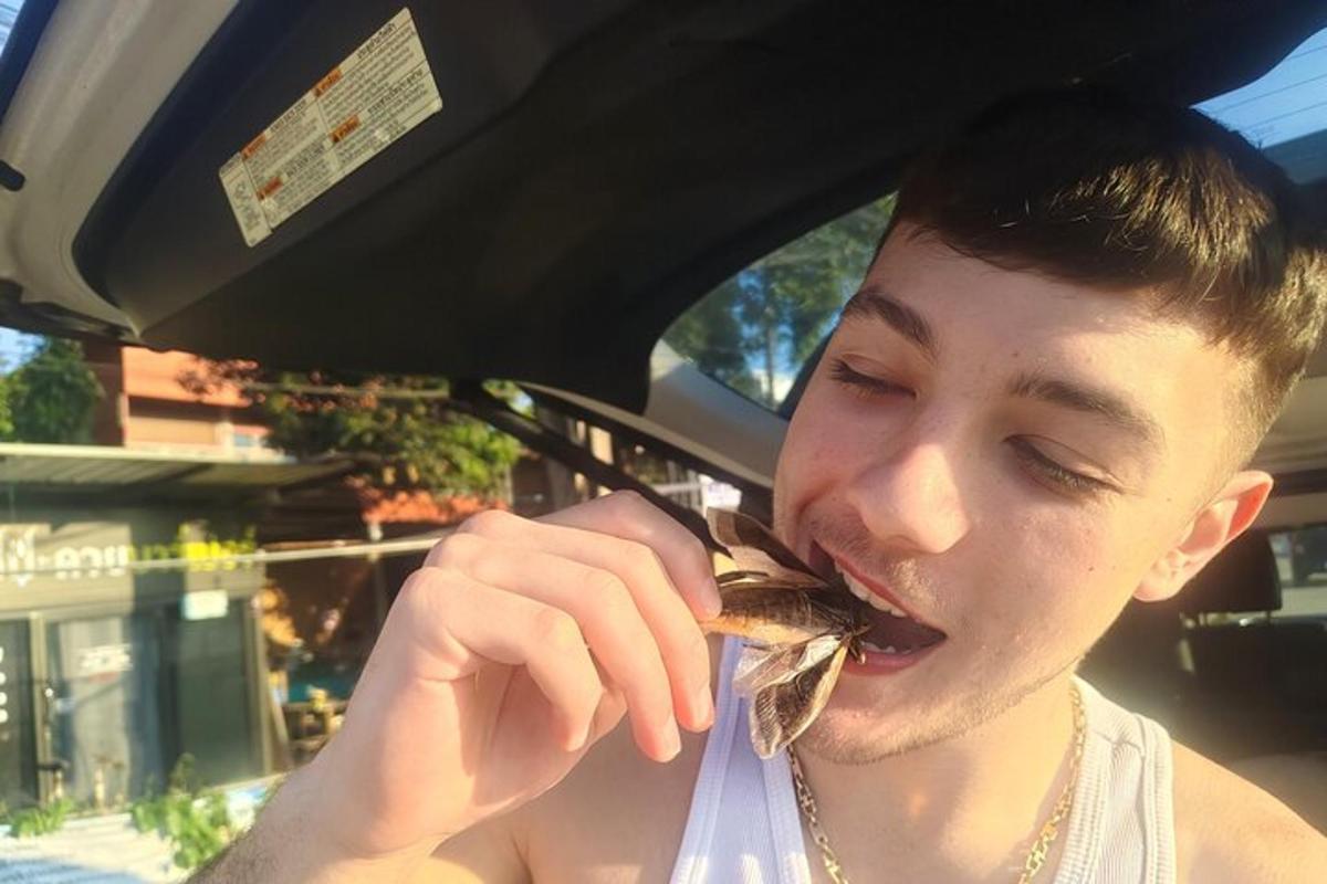 un giovane che mangia un pesce in bocca