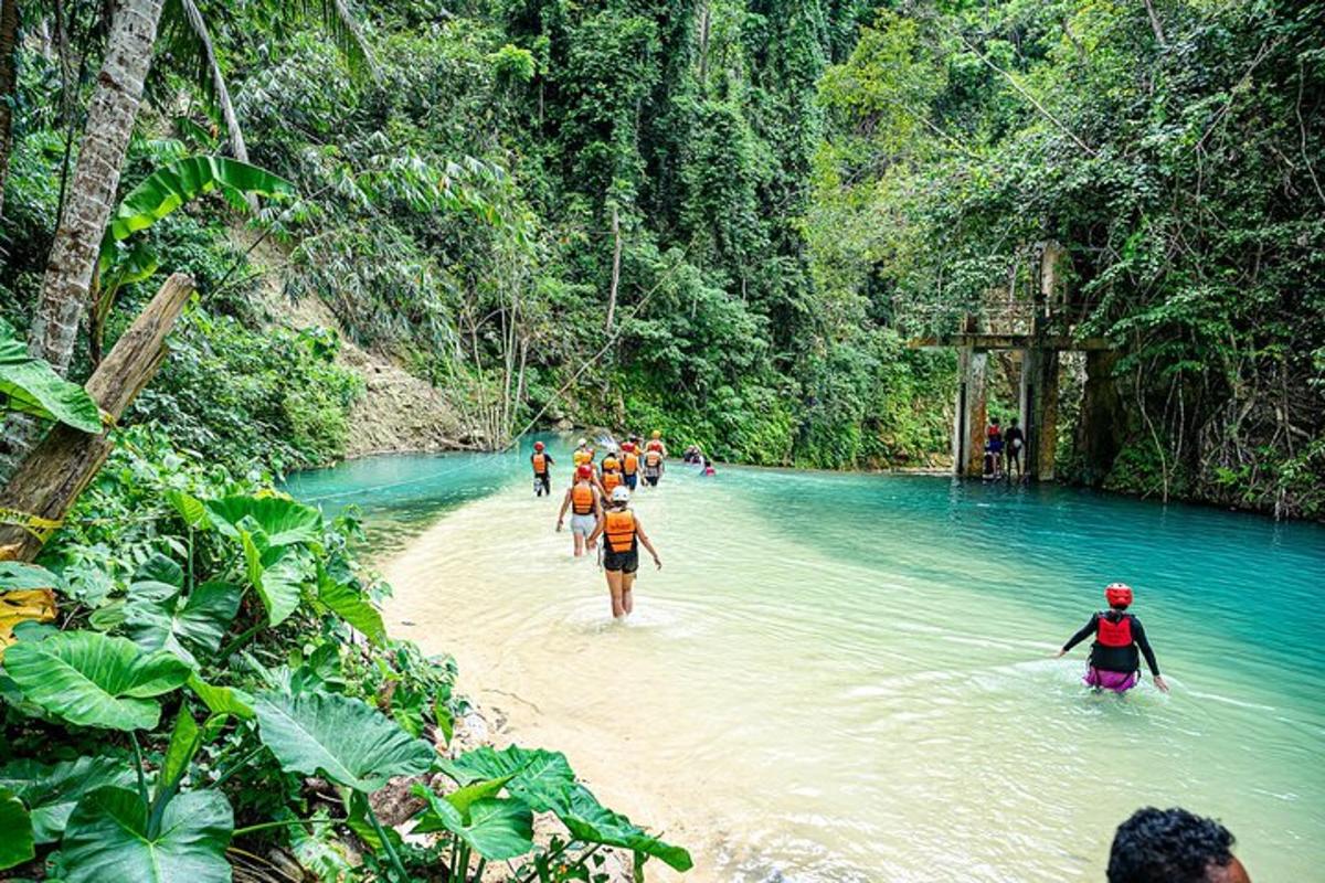 un gruppo di persone che attraversa un fiume nella giungla