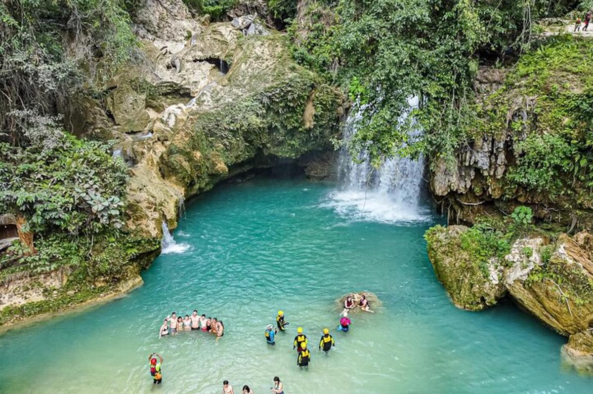 un grupo de personas en un río con una cascada