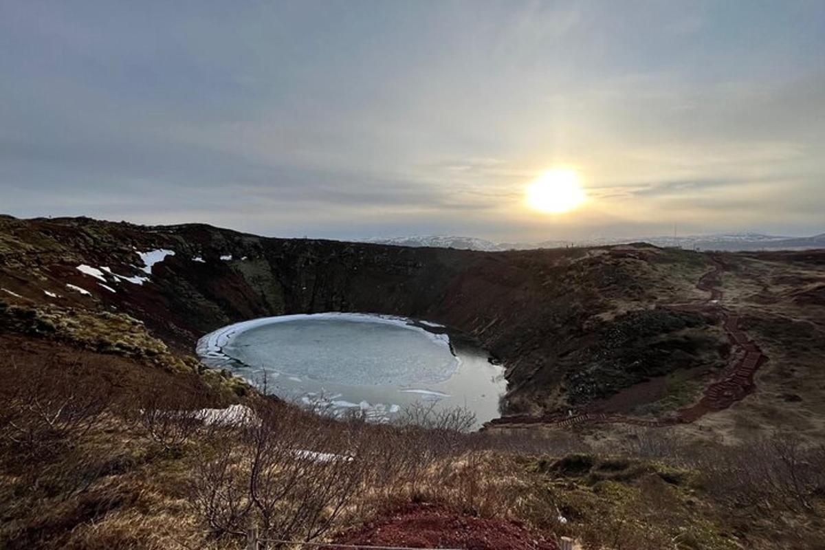jezero na kopci se sluncem v pozadí