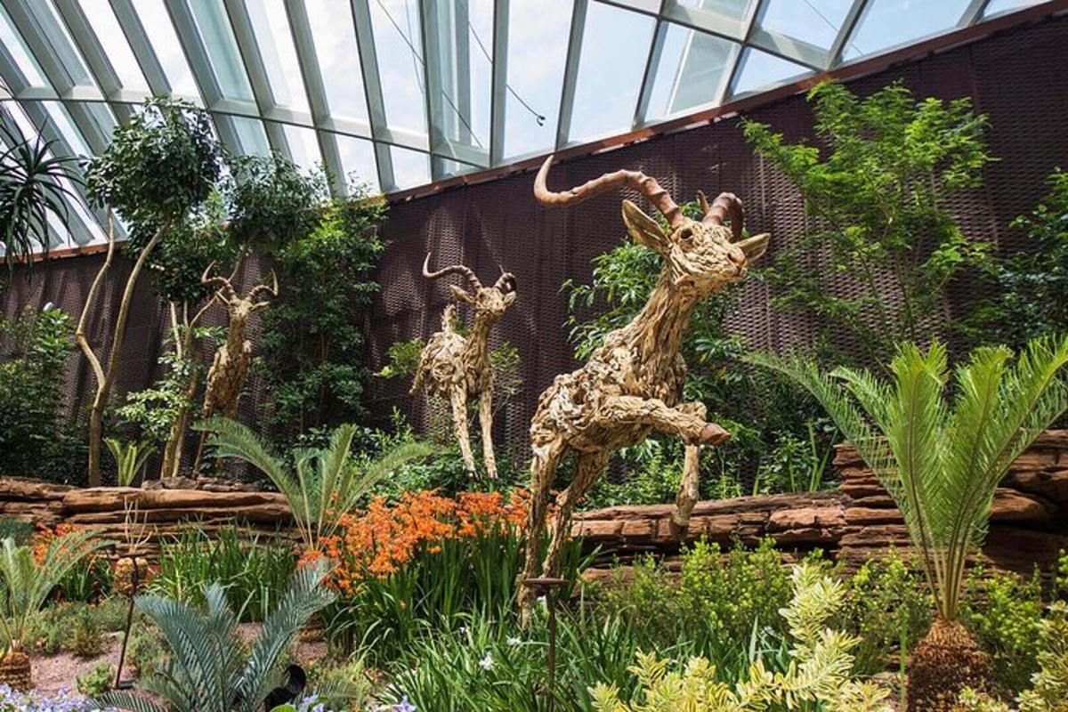 two statues of giraffes standing in a garden
