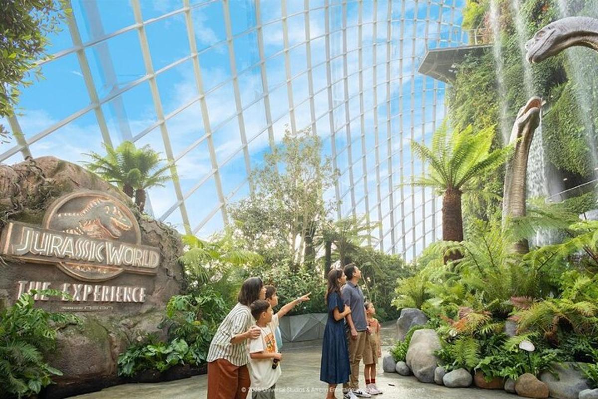 a group of people standing in front of a dinosaur world