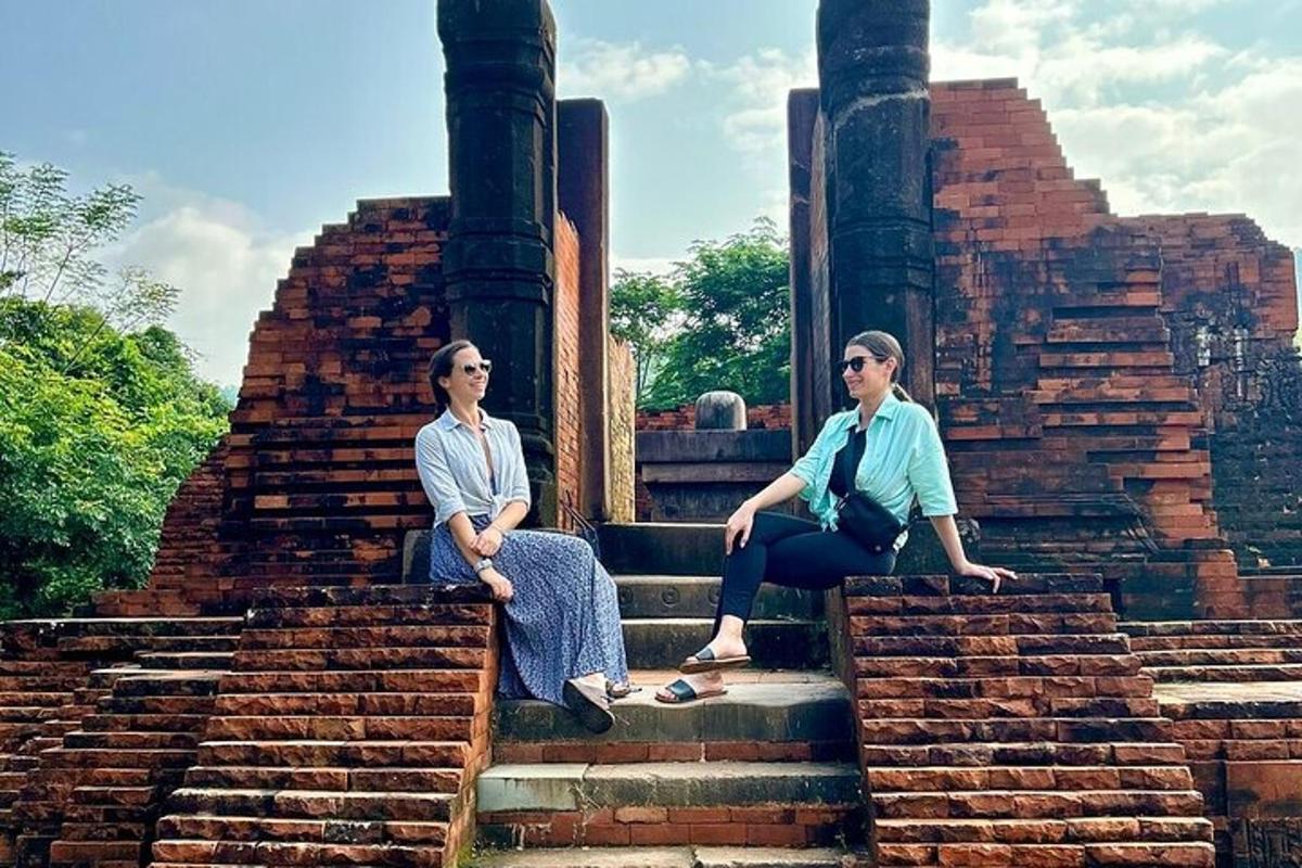 two women sitting on the steps of a temple