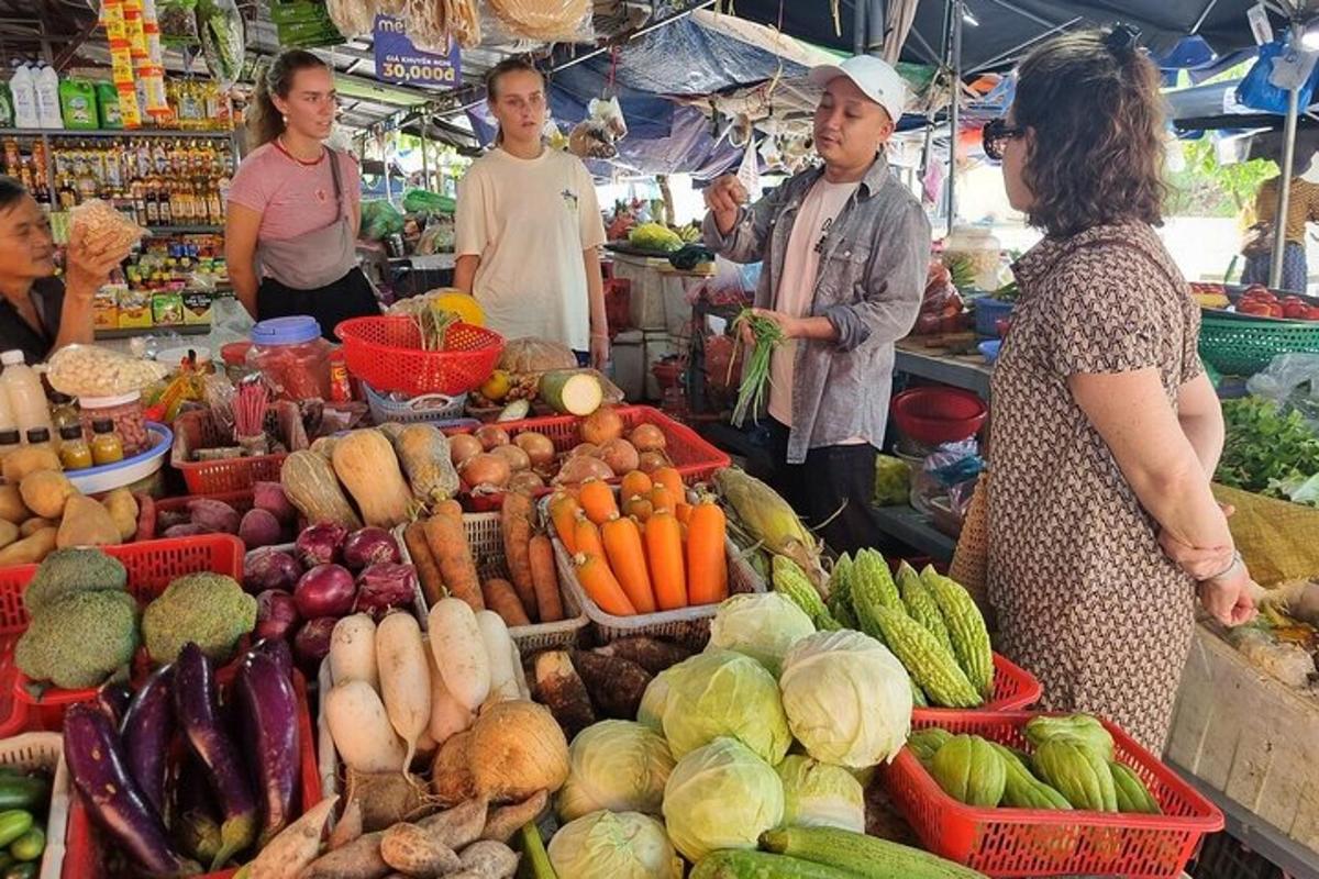 a group of people standing around a market with vegetables