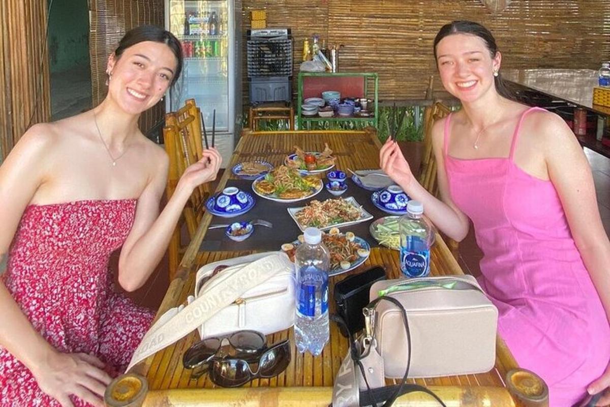 two women are sitting at a table with food
