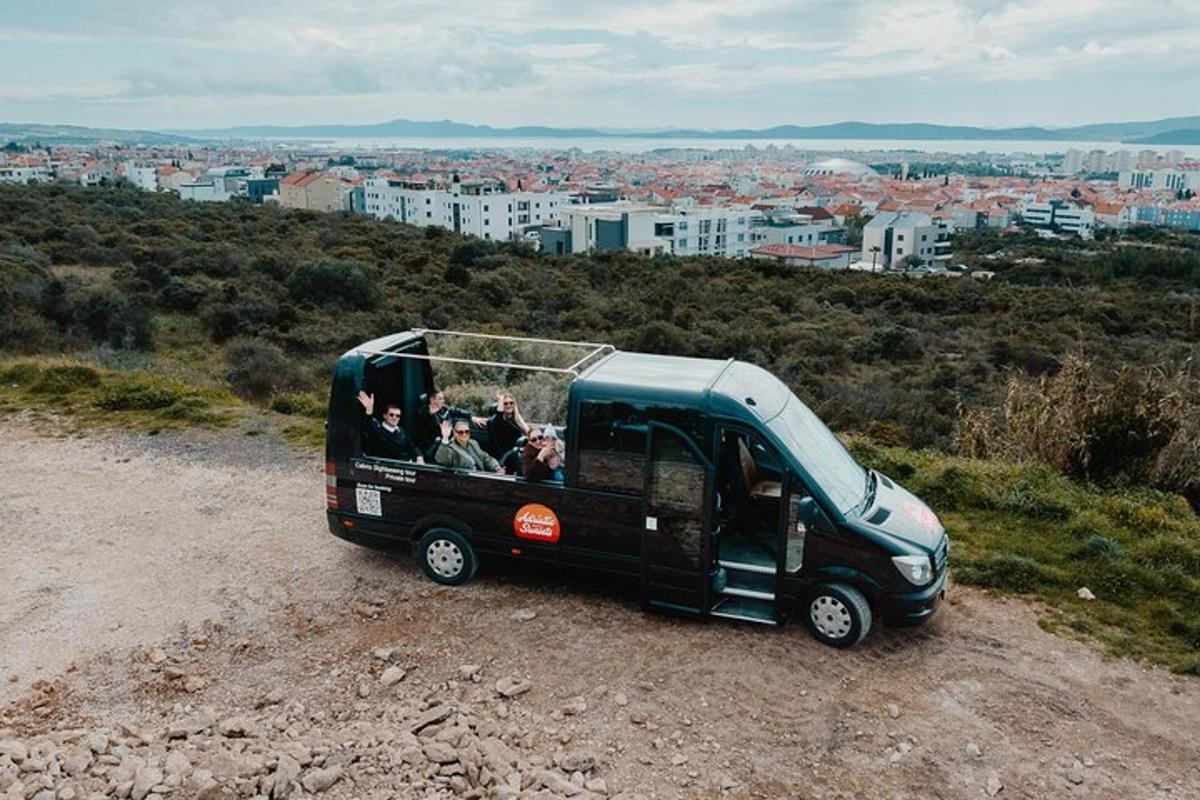 un autobús negre circulant per una carretera de terra