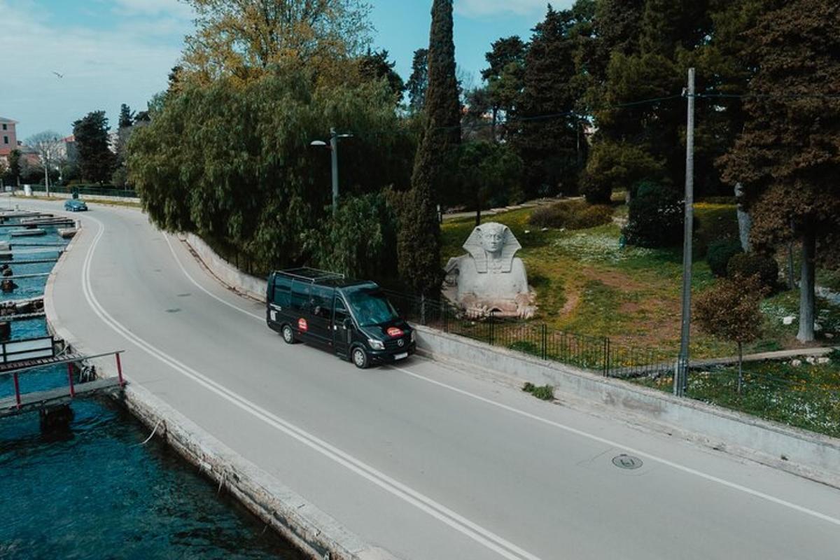 un tot terreny verd conduint per una carretera al costat d'un riu