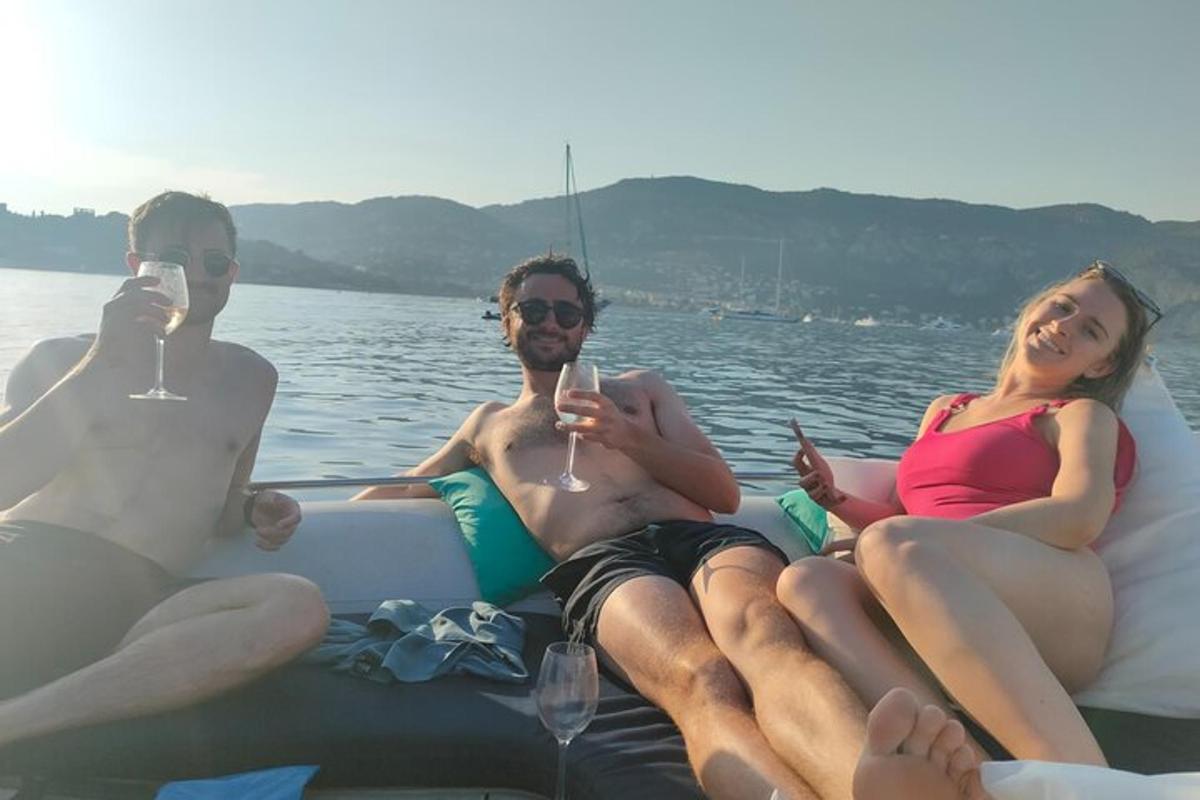 tři lidé sedící na lodi se sklenicemi vína