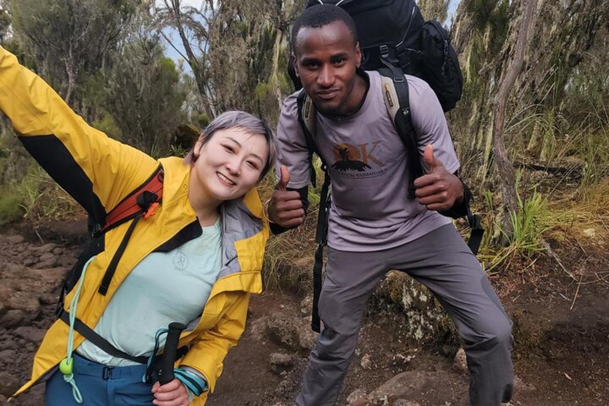 a man and a woman giving thumbs up on a trail