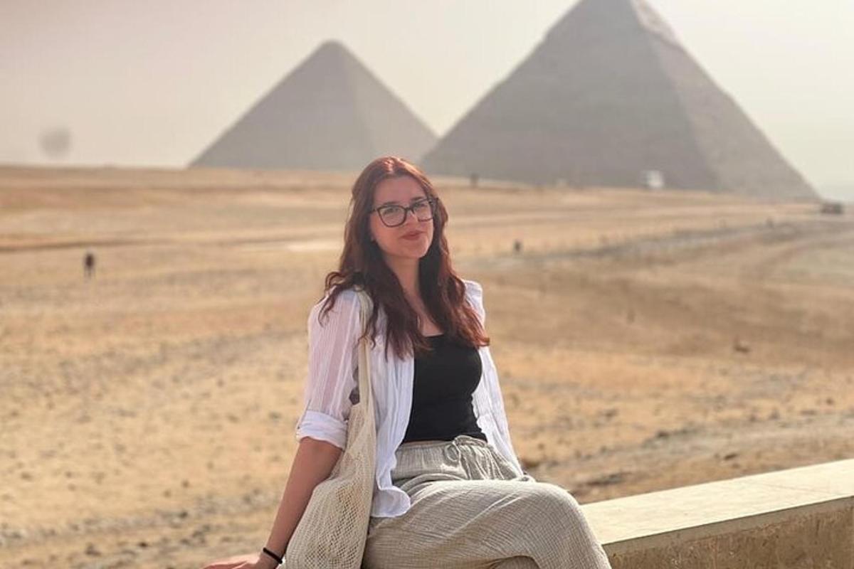 žena sediaca na rímse pred pyramídami