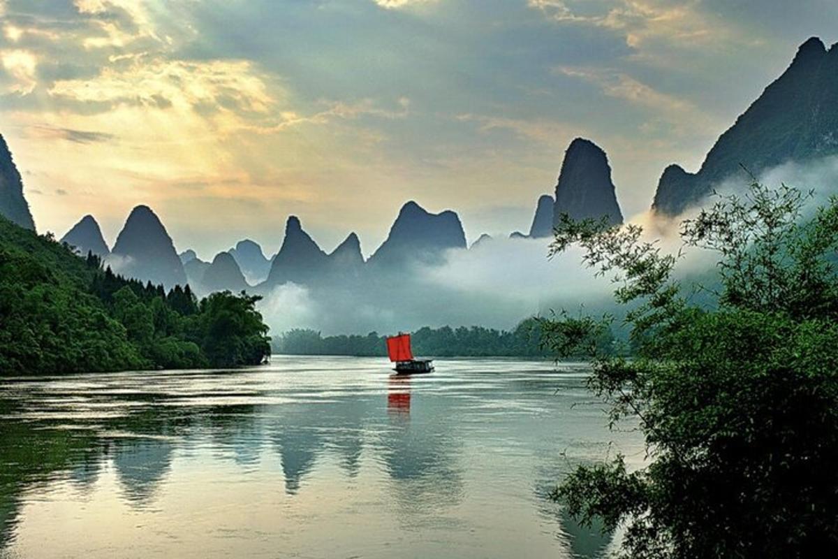 a boat on a river with mountains in the background