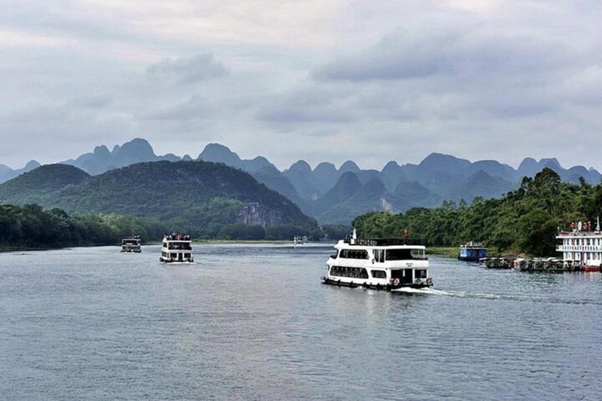 three boats on a river with mountains in the background