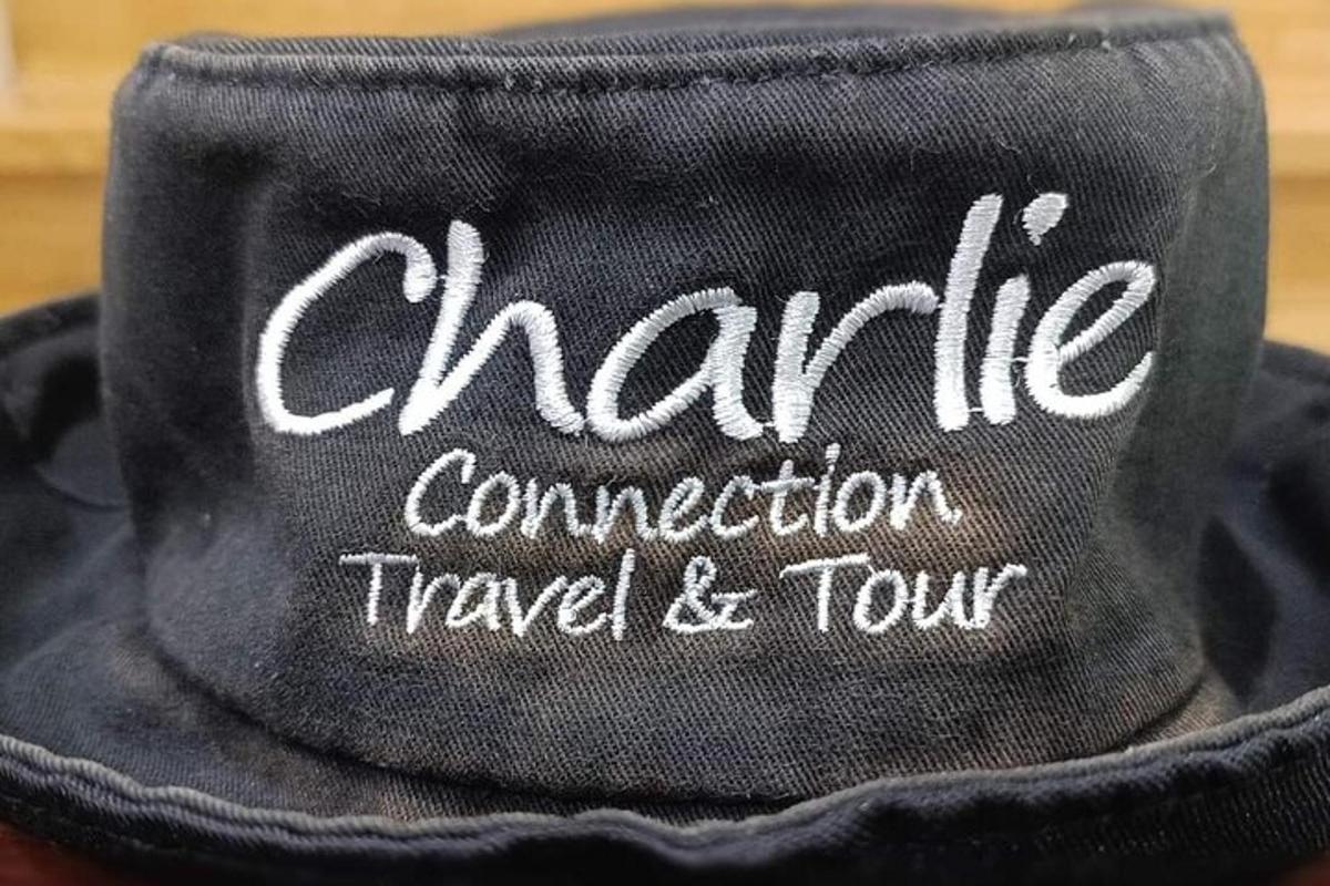 topi hitam dengan kata-kata charma komunikasi perjalanan dan wisata