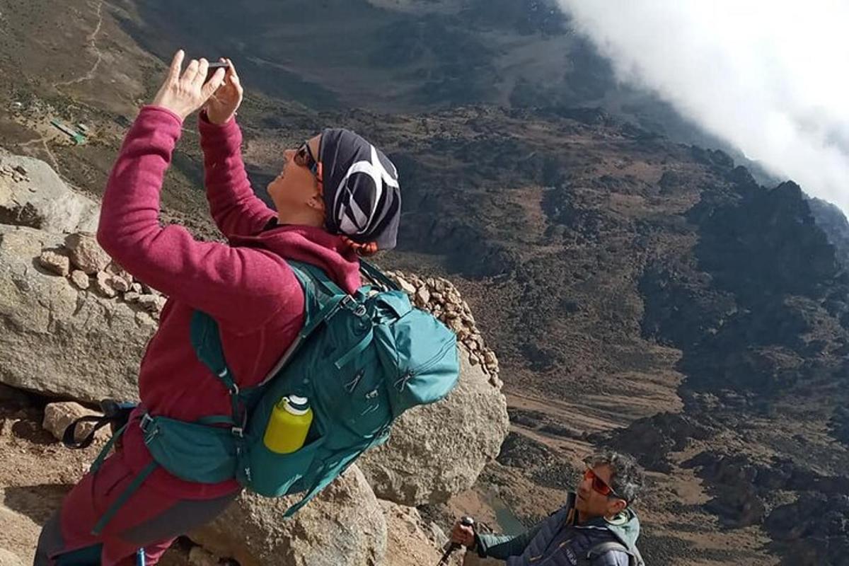 kona stendur á fjallshlíð