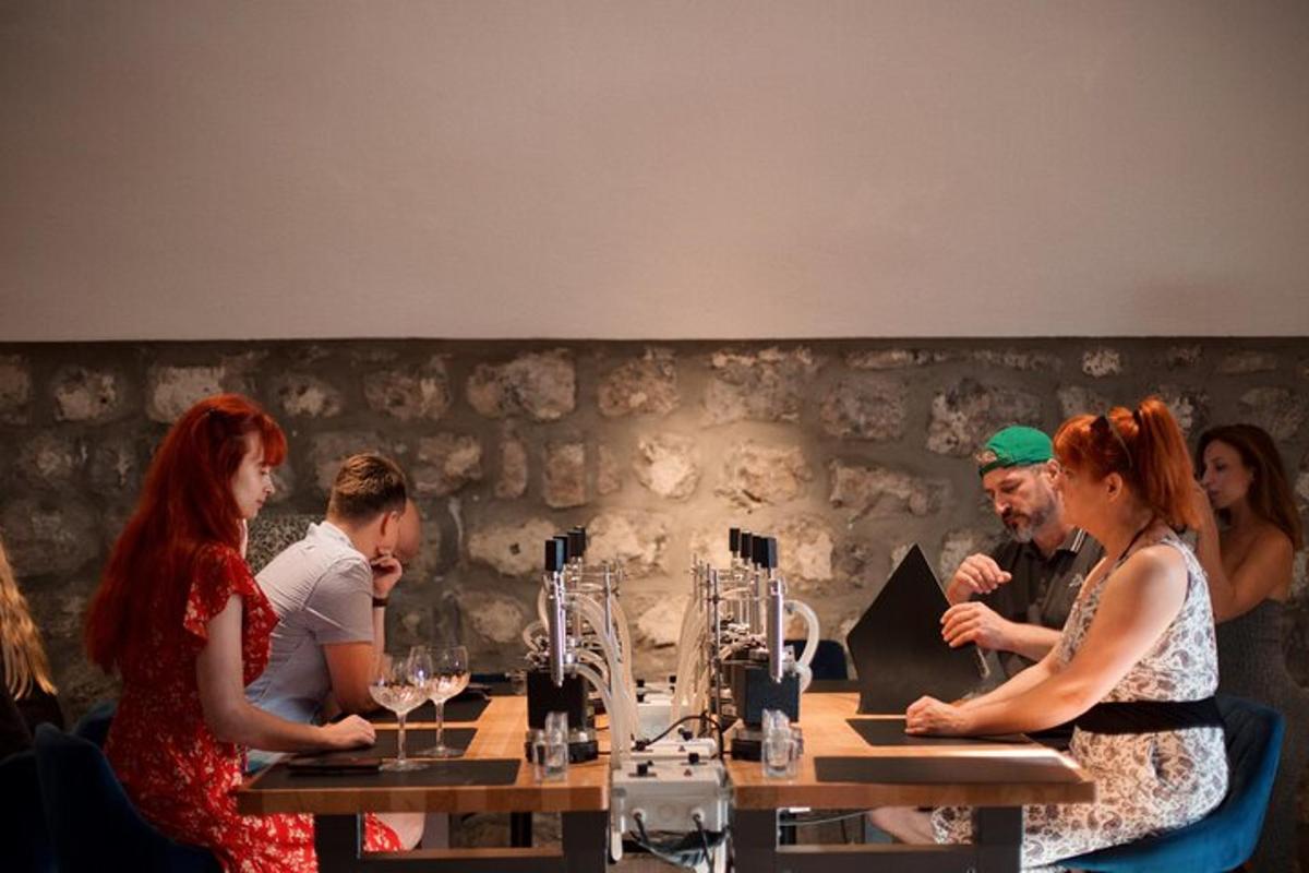 un gruppo di persone sedute a un tavolo con bicchieri di vino
