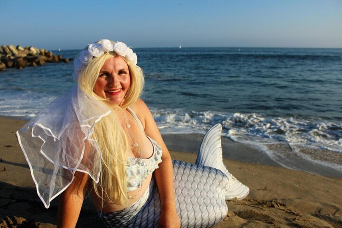 kobieta w sukni syreny siedząca na plaży