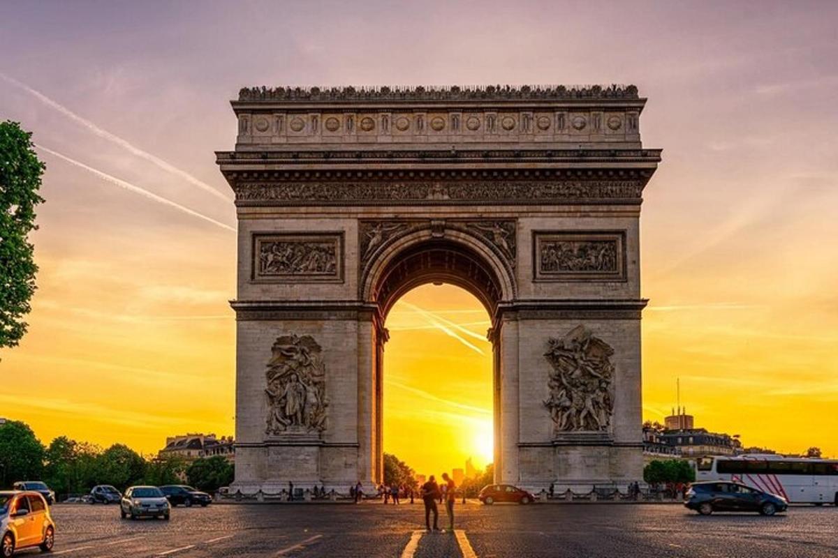 a large monument with the sun setting behind it