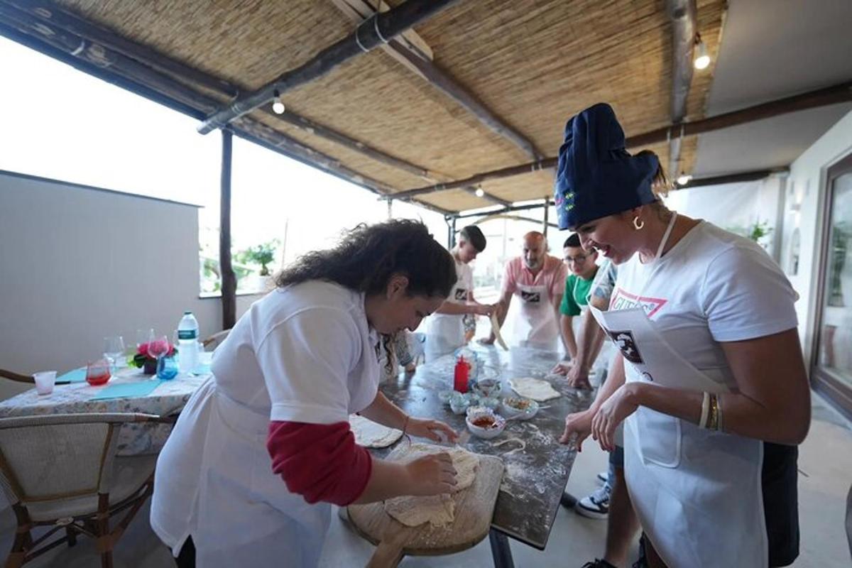 skupina žen stojící kolem stolu a připravující jídlo