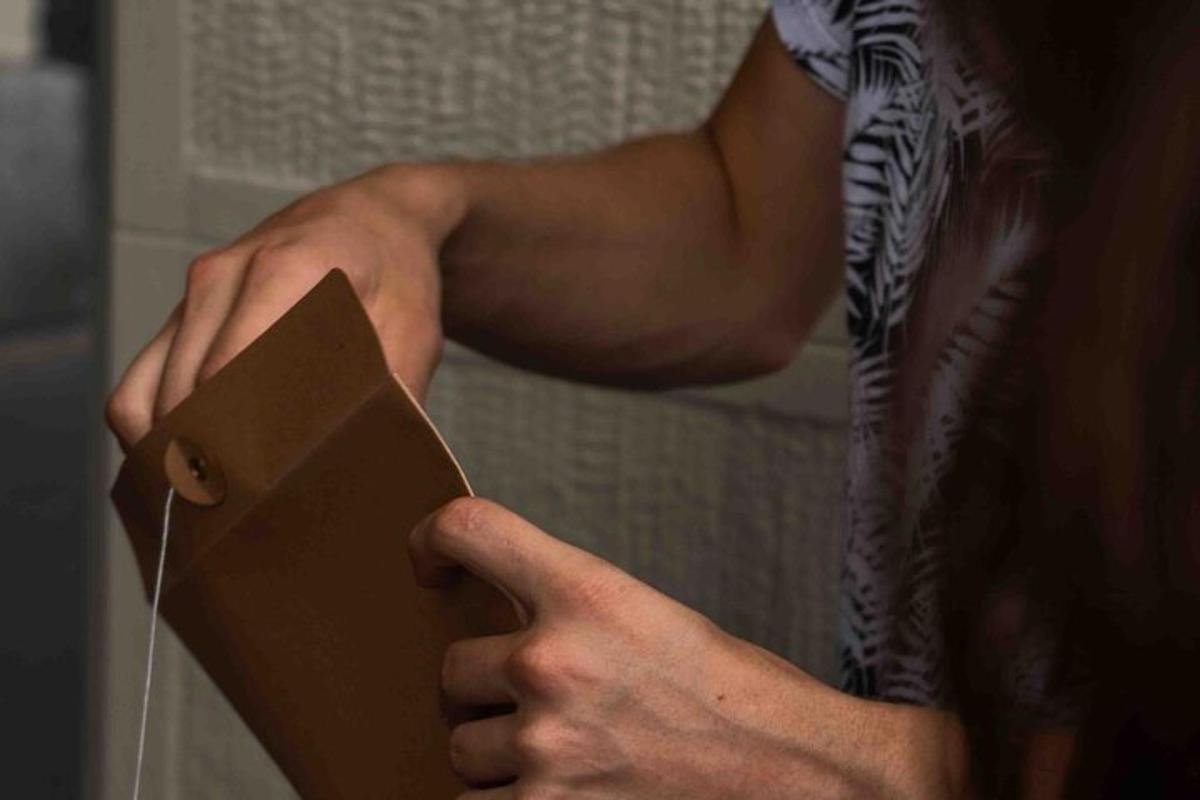 henkilö, jolla on ruskea laatikko käsissään