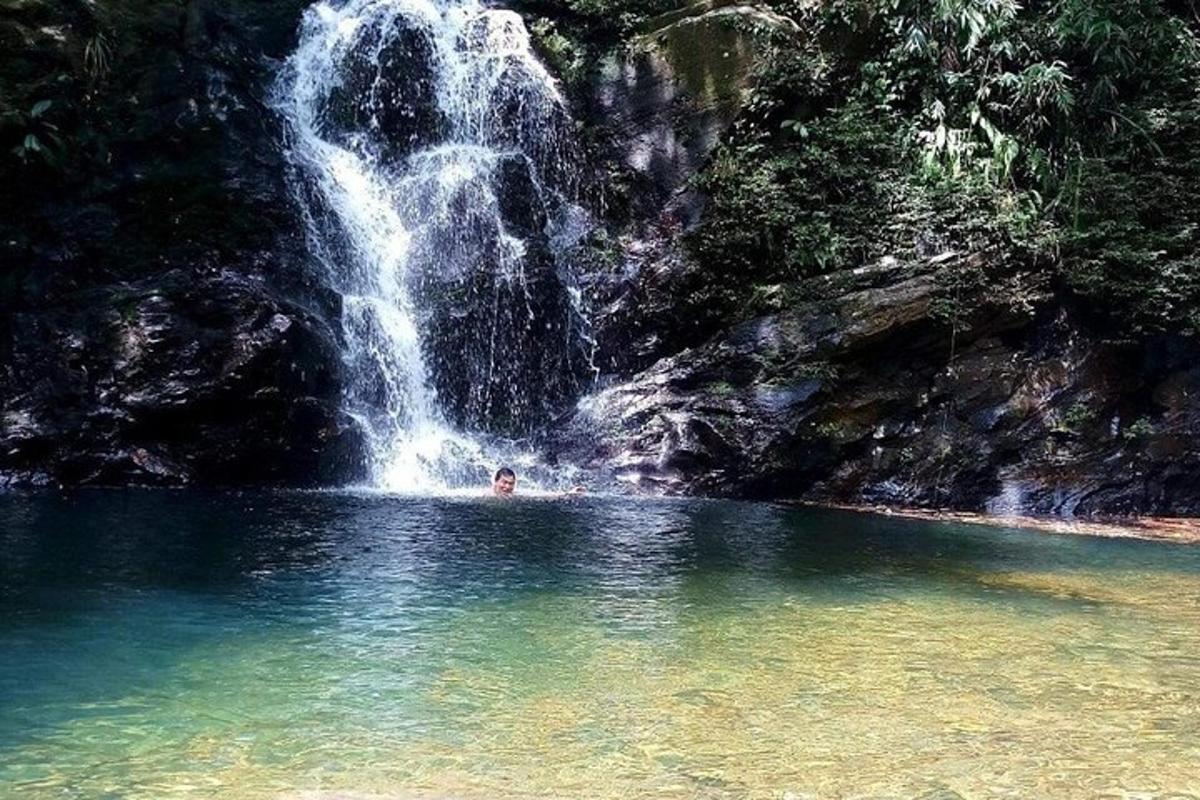 un uomo che nuota in una piscina di fronte a una cascata