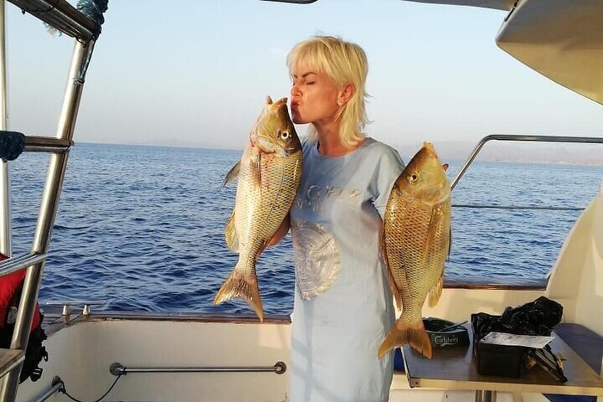 a woman holding two fish on a boat
