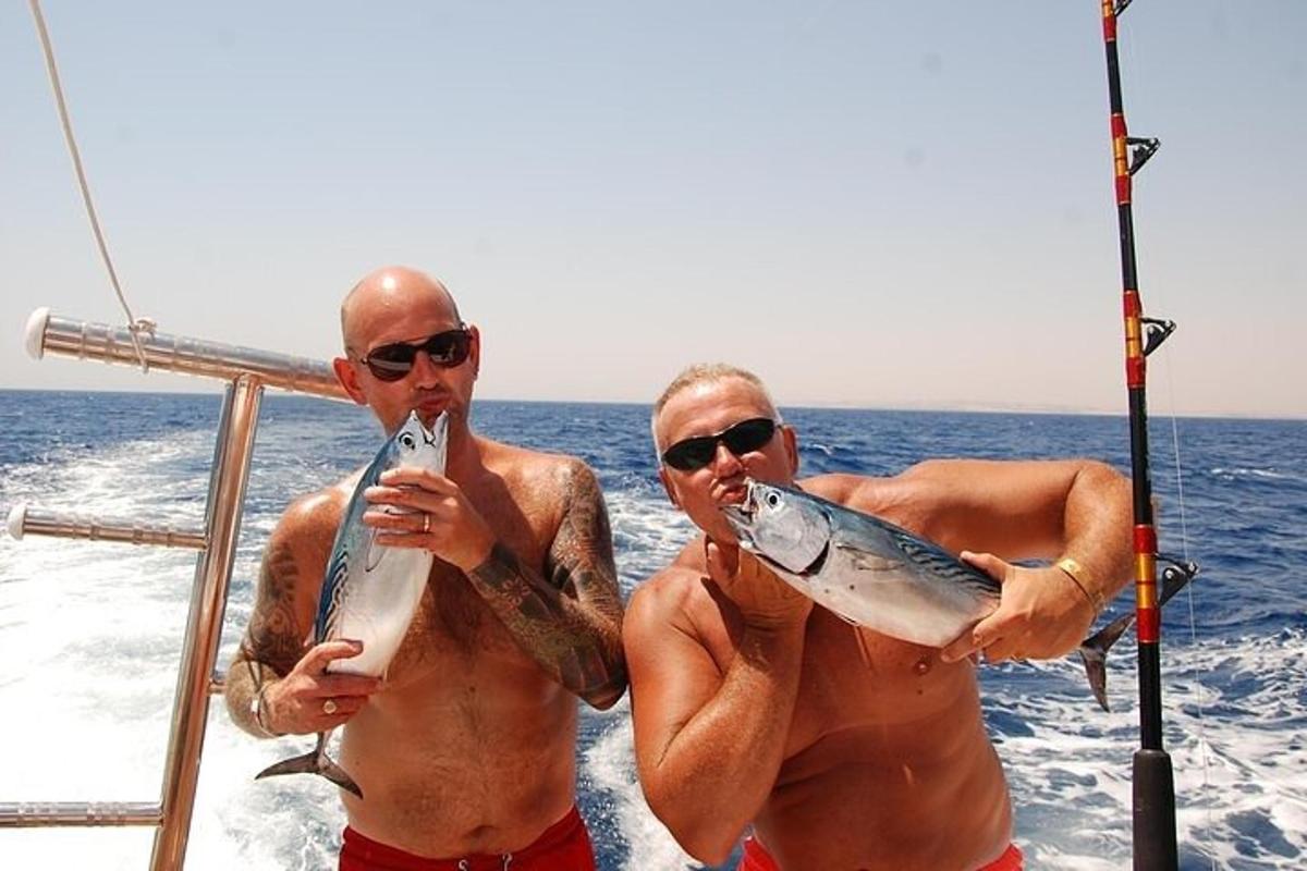 two men on a boat with fish in their mouths