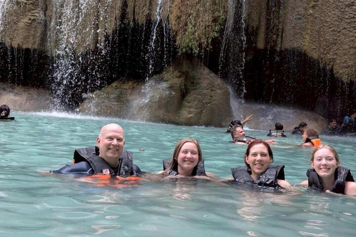 un gruppo di persone che nuotano in una cascata