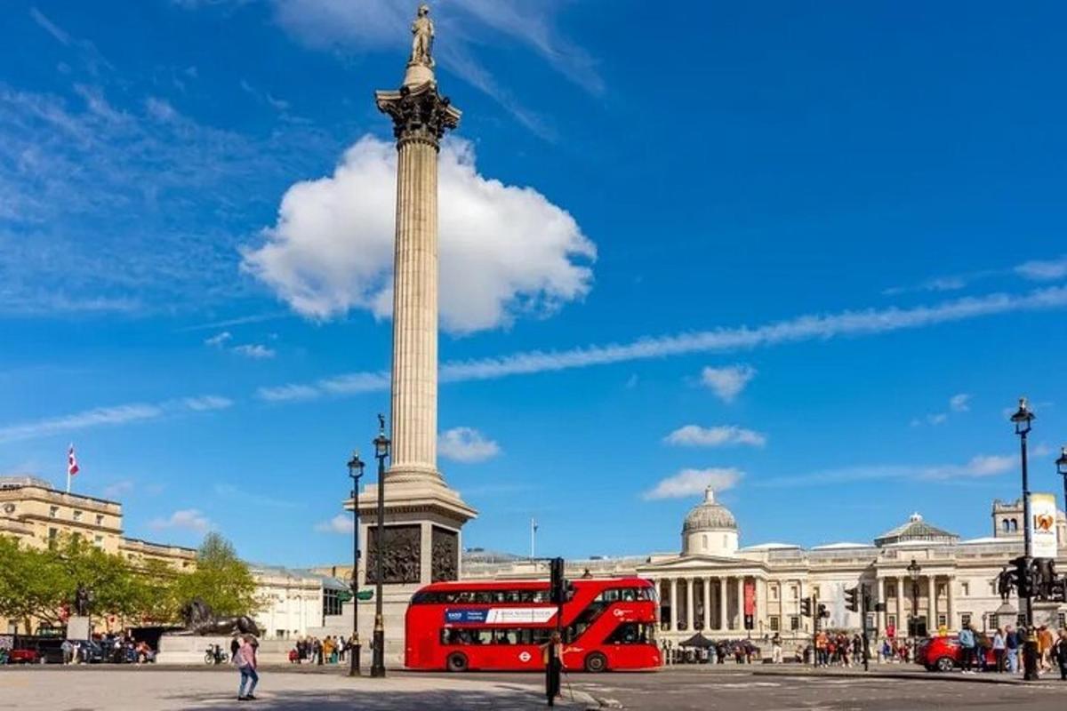 Un autobús rojo de dos pisos frente a un monumento