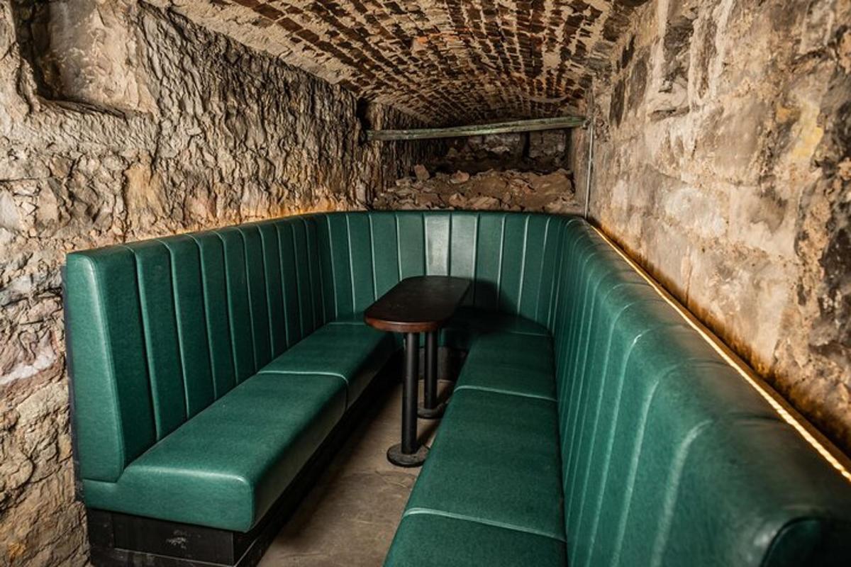 Una cabina verde con un taburete y un sofá verde.