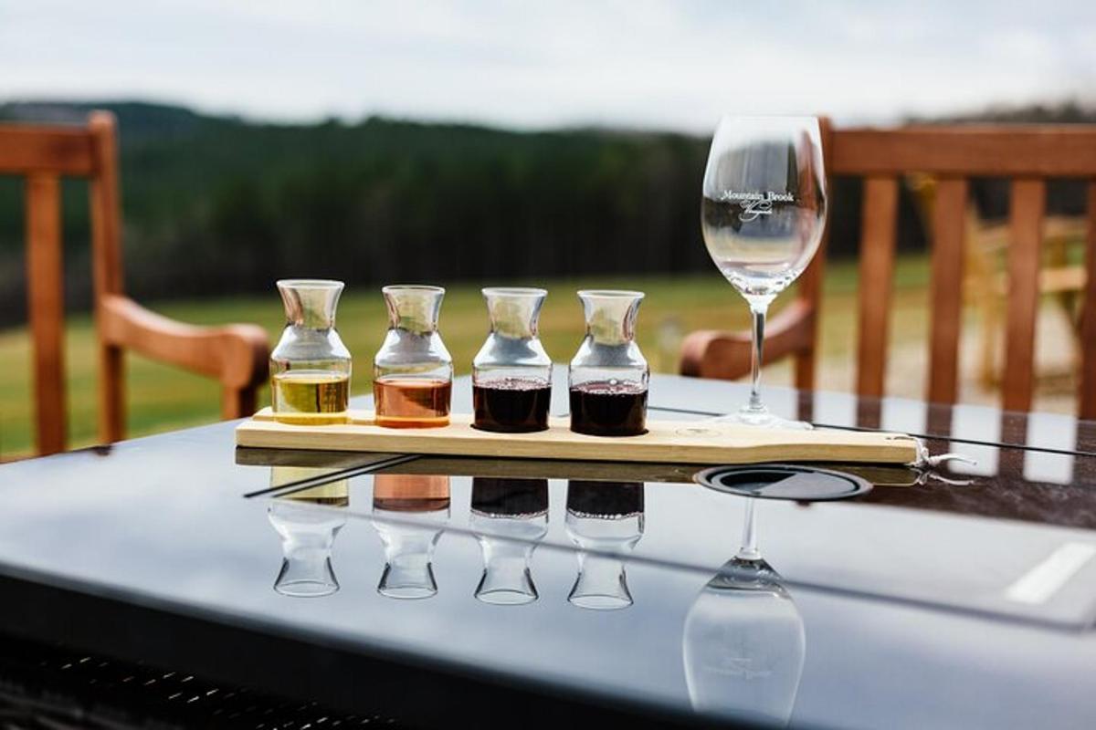 a table with four bottles and a wine glass