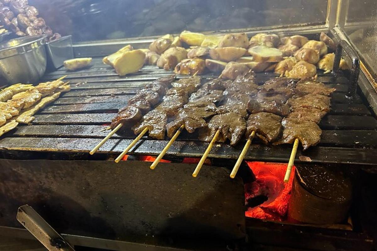 a bunch of meat on a grill with chop sticks