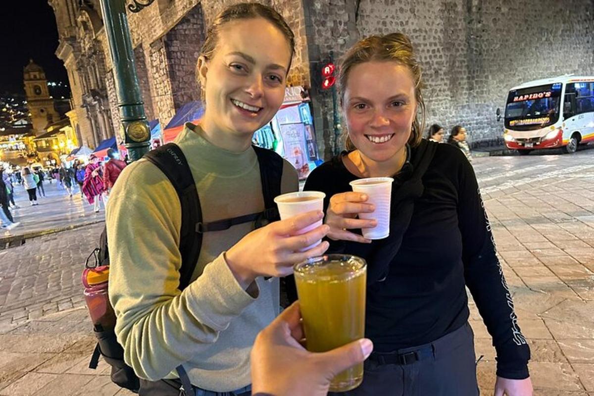 two people holding up drinks in front of a building