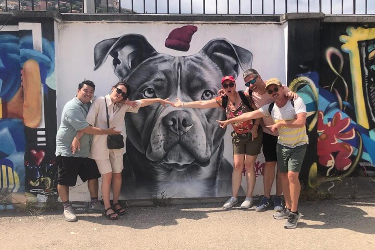 Un grupo de personas de pie frente a un cuadro de un perro.