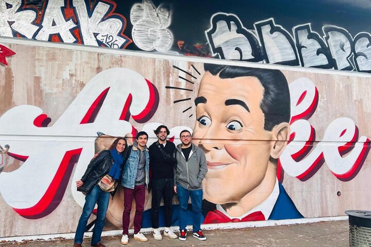 skupina lidí stojících před nástěnnou malbou