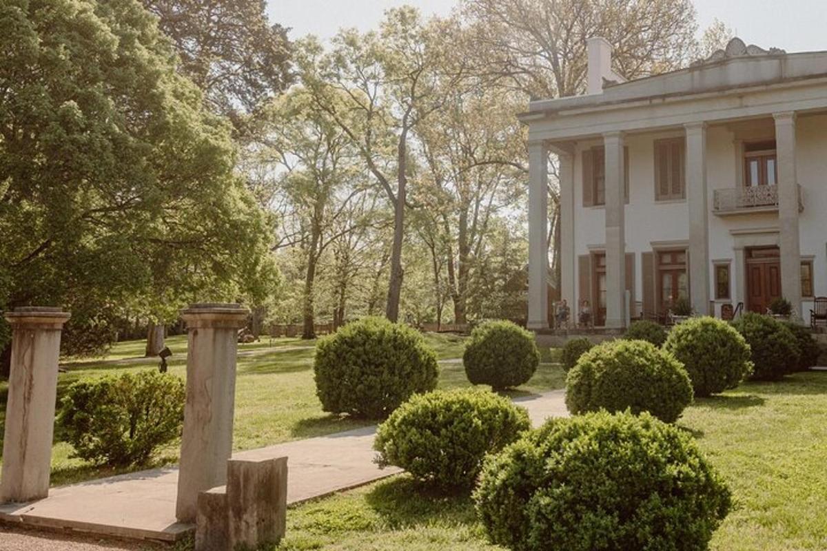 a large white house with bushes in front of it
