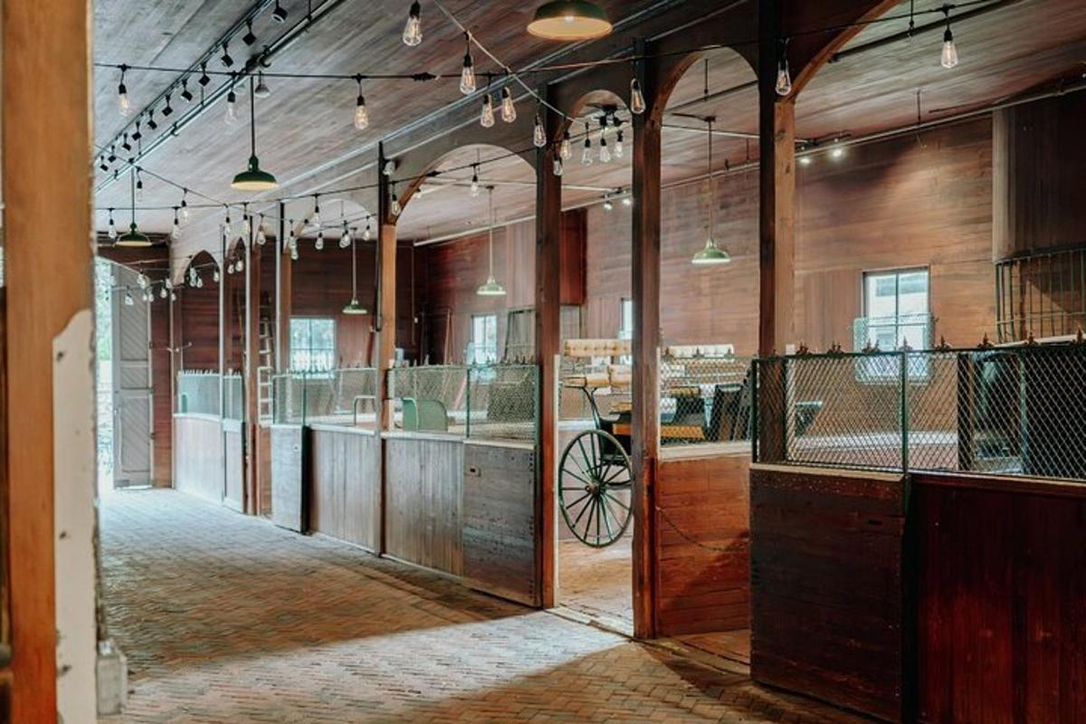 an empty barn with a carriage in the middle