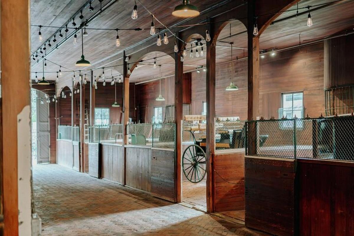 an empty barn with a carriage in the middle