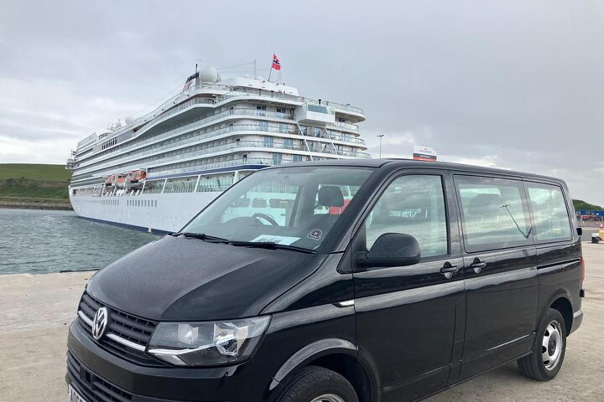 a black van parked in front of a cruise ship