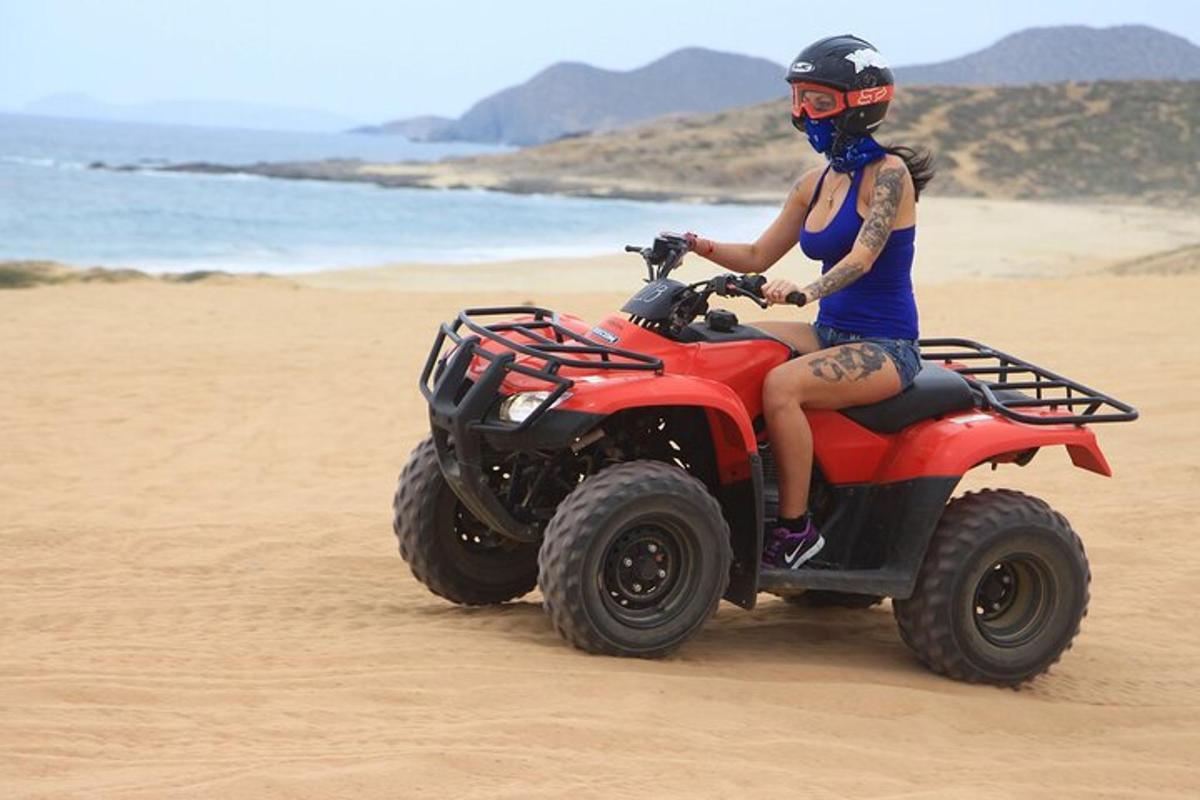 a woman riding a quad bike on the beach