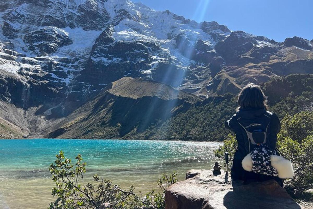 žena sedící na skále s výhledem na horské jezero