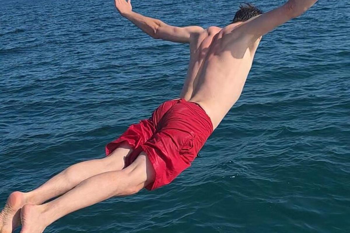 a young man is jumping into the water
