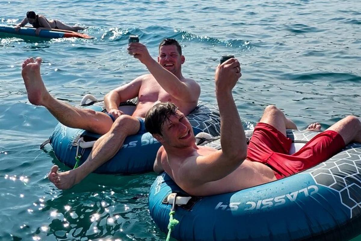 two men are laying on rafts in the water