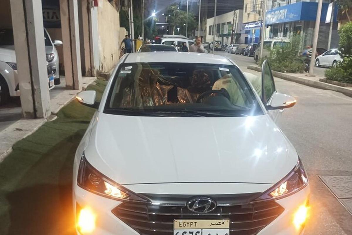 um carro branco estacionado na beira de uma rua